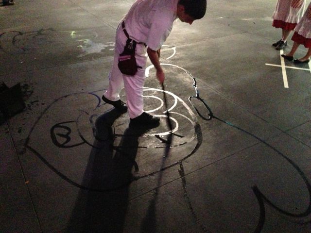 Disney janitor painting character on sidewalk with water and broom