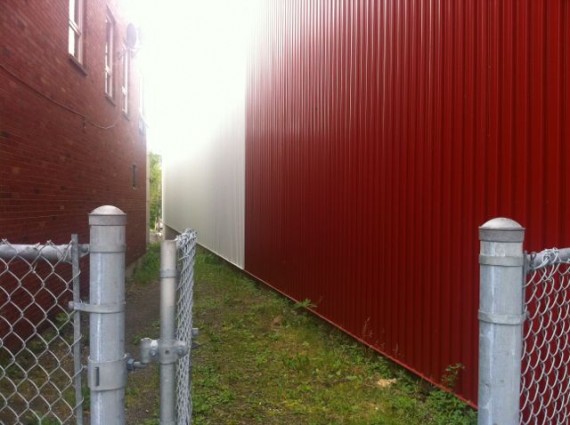 random, photo of two red buildings and a fence gate