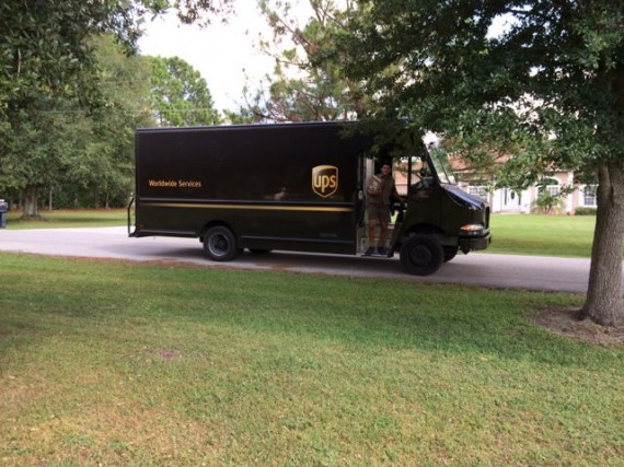 UPS delivery truck driver stepping off truck