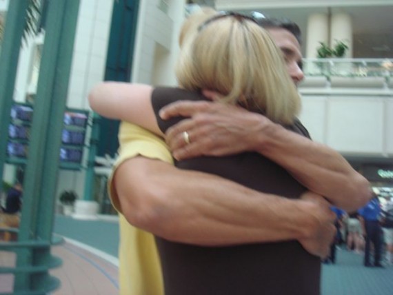 Husband and wife hug at airport