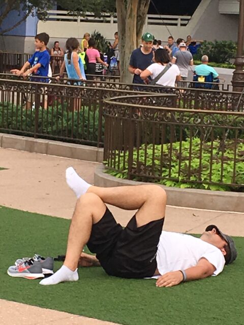 exhausted Guest resting on ground in Magic Kingdom