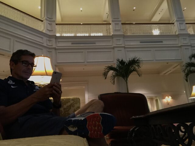man using phone in hotel lobby