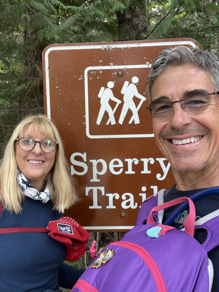 Couple standing in front of Trail head sign