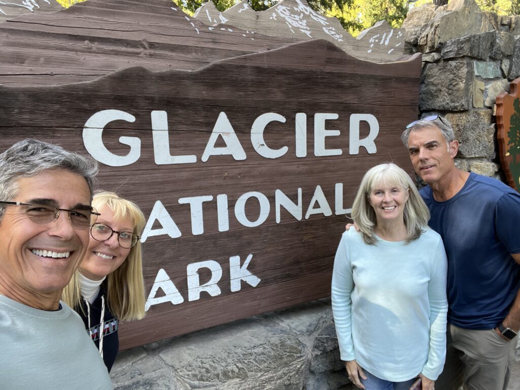 Four people next to National Park sign