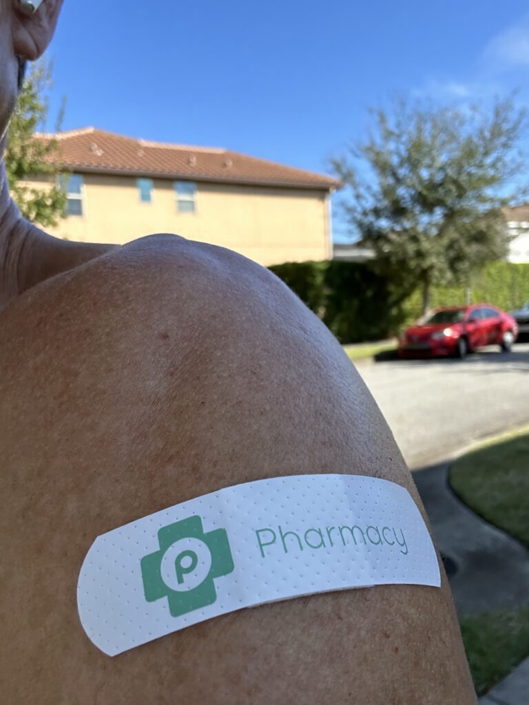 Man’s bare arm with Publix band aide