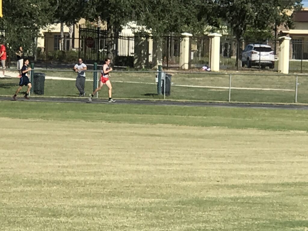 two high school cross country runners in the distance