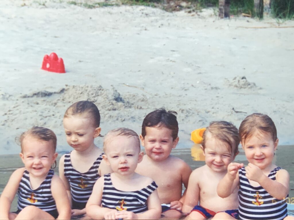 six toddlers in bathing suits on a dock