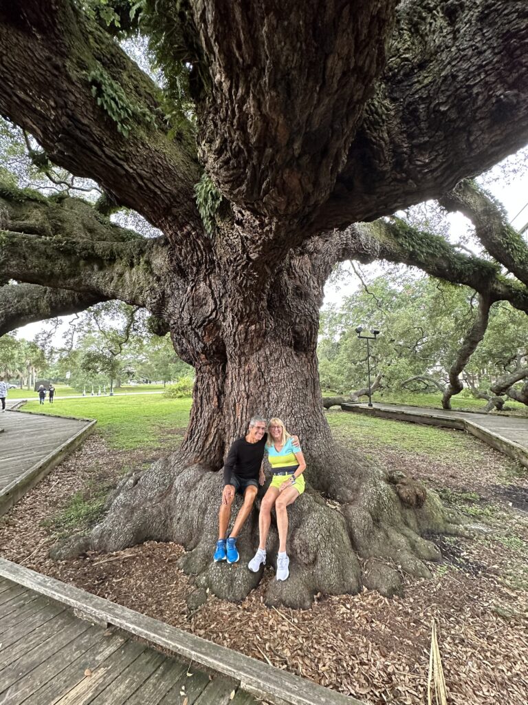 Couple sitting at base of massive Florida Live Oak tree