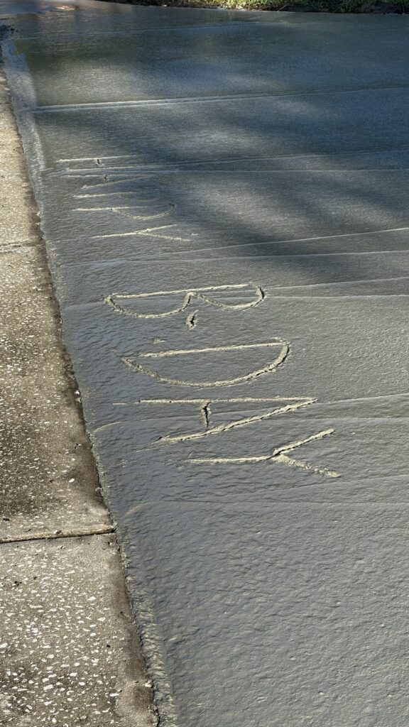Happy birthday message carved into wet concrete