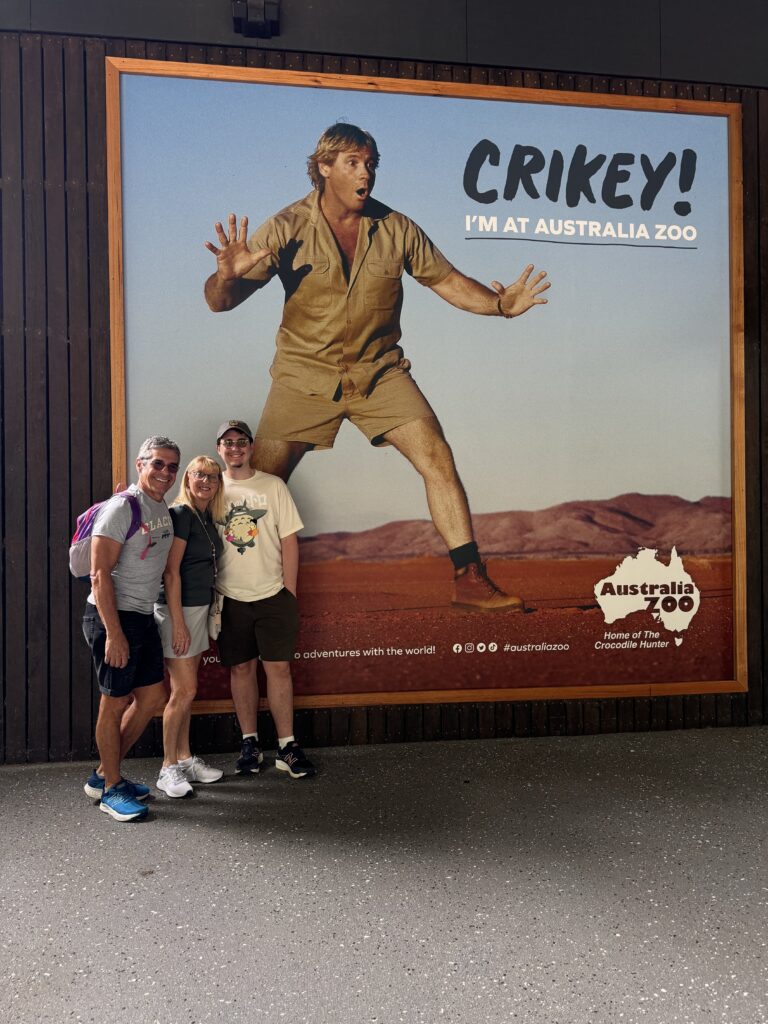 Three adults at zoo sign