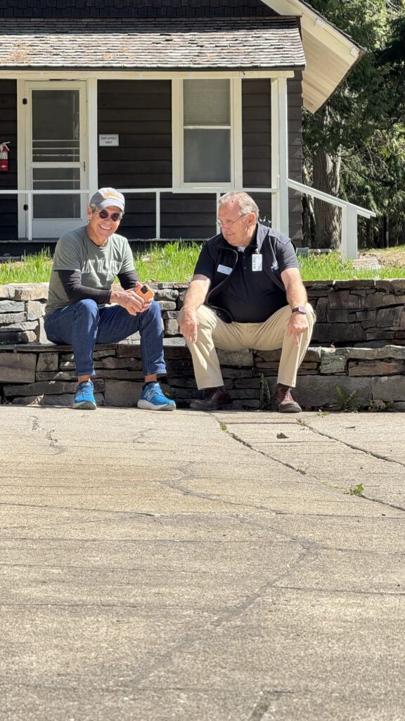 Two men sitting on a stone wall