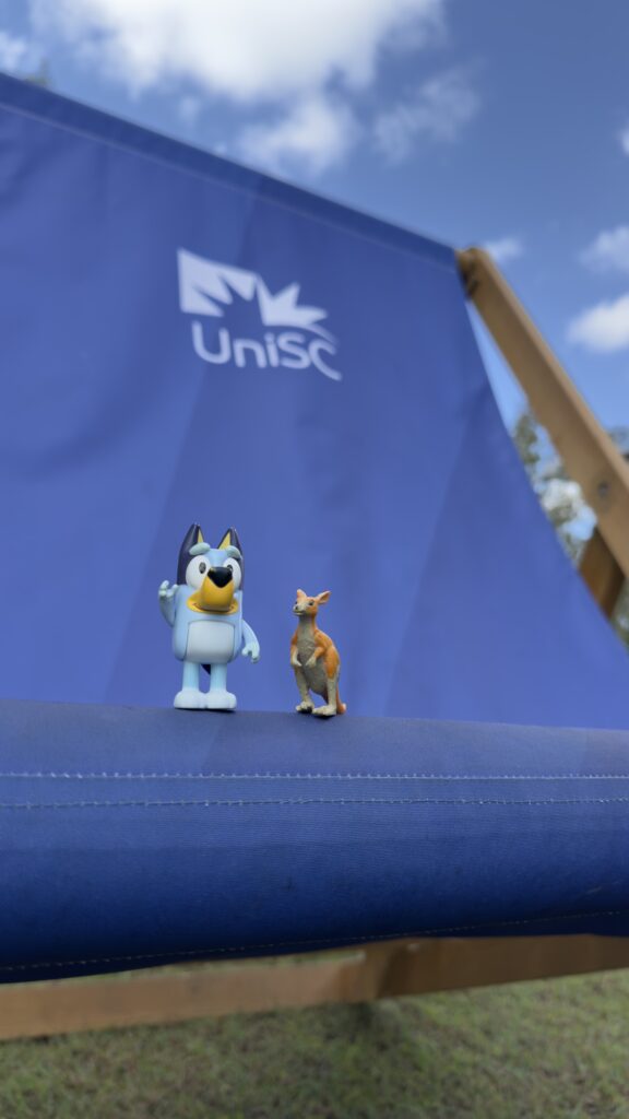 two small toy figurines on a blue chair
