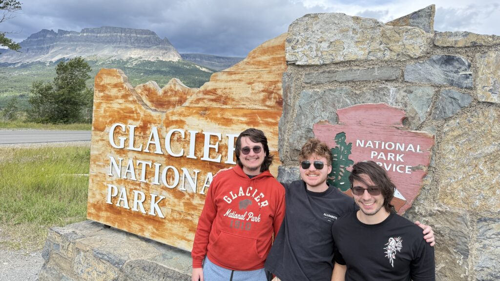 three men at a national park sign