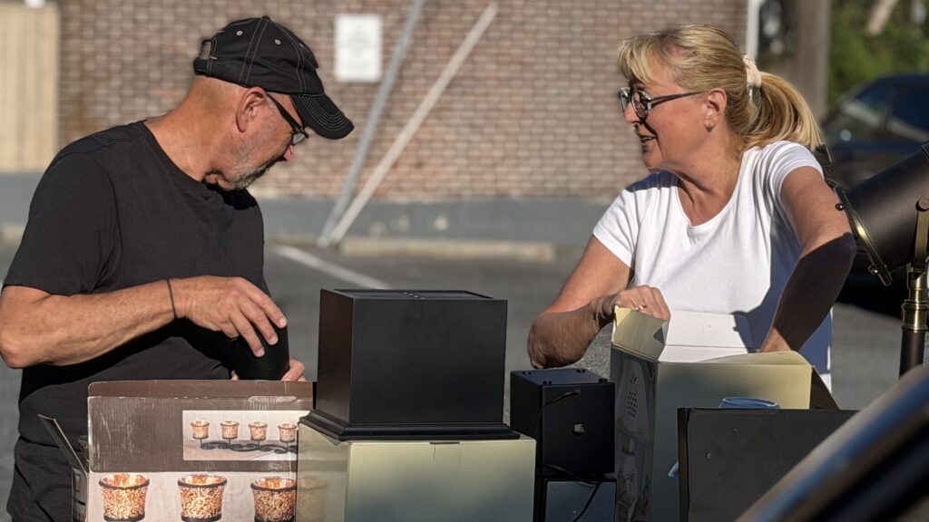 Two seniors setting up for yard sale