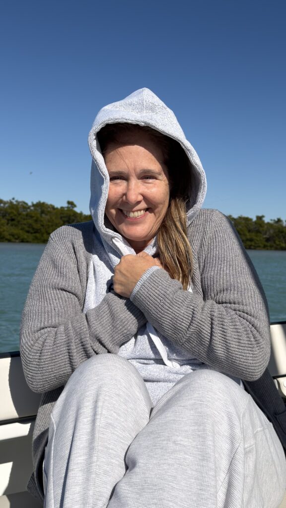 Woman bundled up trying to keep warm on a boat